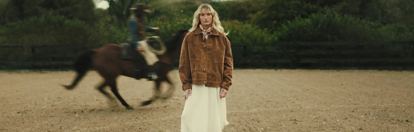 Eine Frau in einem Paar Westernstiefel von Durango vor einem galoppierenden Pferd